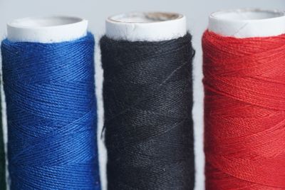 Close-up of multi colored thread spools on white background