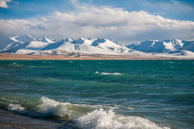 The heavenly lake namtso in tibet with snow covered nyenchen tanglha mountains in the distance