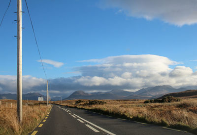 Road passing through landscape against sky