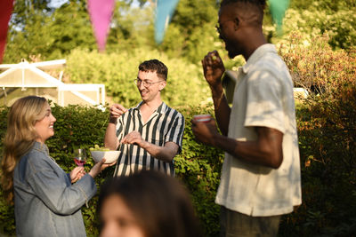Side view of mother and daughter standing in park