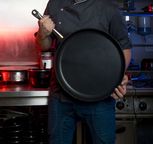 Man holding saucepan at home