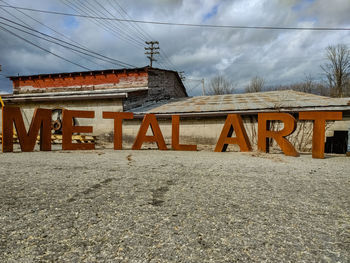 Low angle view of text on building against sky