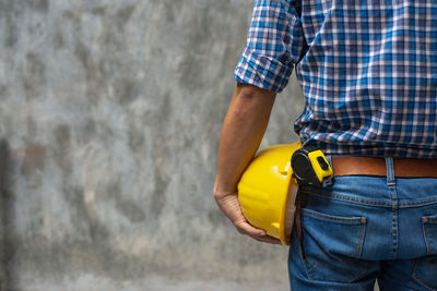 Low angle view of man working on wall