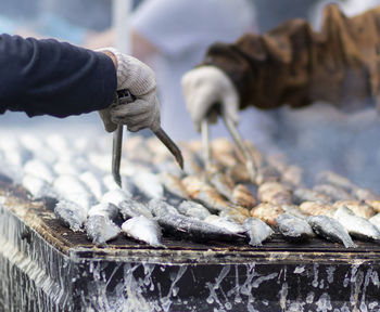 Cropped hands grilling fish