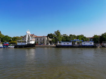 River by buildings against clear sky