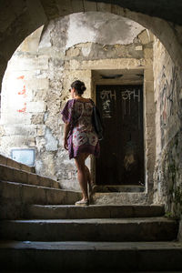 Rear view of woman walking on steps