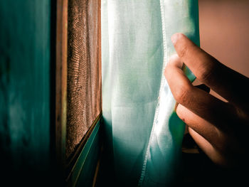 Close-up of hand holding window