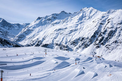 Skilift and drag lift on snow covered mountains against sky in alps