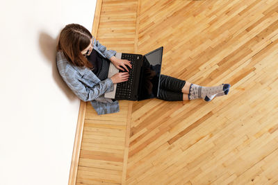 High angle view of woman relaxing on hardwood floor at home