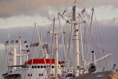Sailboats moored in harbor against sky