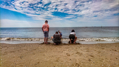 People on beach against sky