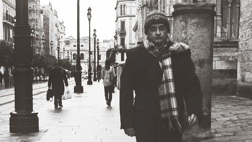 Portrait of young man standing on street in city