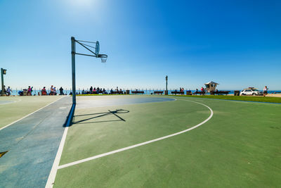 Scenic view of soccer field against clear blue sky
