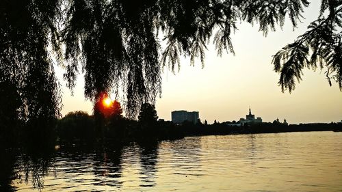 Sunset over river with buildings in background