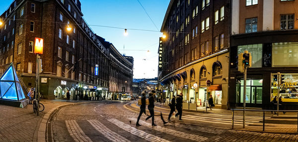 People walking on illuminated street at night