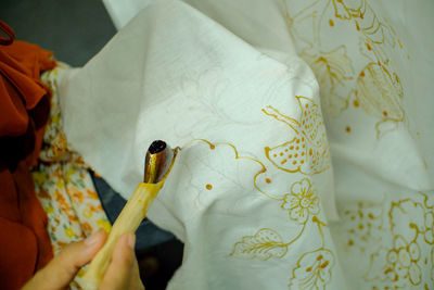 High angle view of woman making embroidery on textile