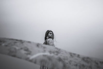 Portrait of woman standing against sky