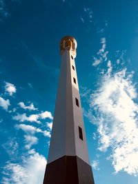 Low angle view of minaret against cloudy sky