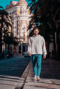 Portrait of young man standing against building