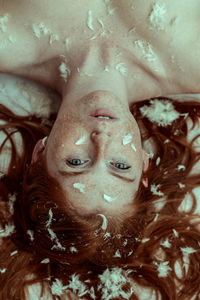 Close-up portrait of young woman with freckles on face