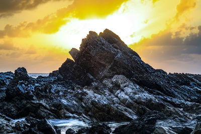 Rock formation against sky during sunset