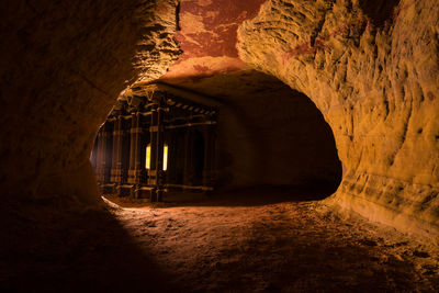 View of illuminated tunnel seen through cave