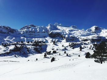 Scenic view of snowcapped mountains against clear blue sky