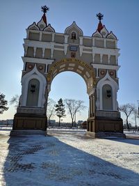 Built structure on snow covered field against sky