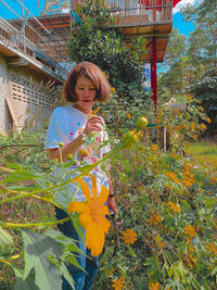 Woman standing by flowering plants