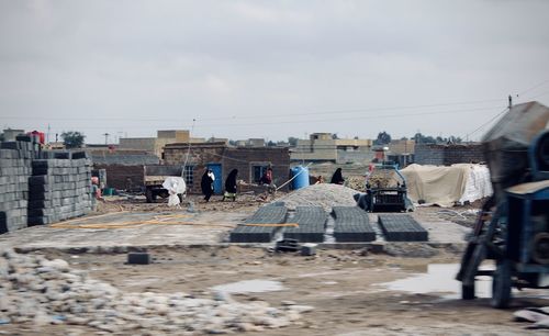 People working on building against sky in city