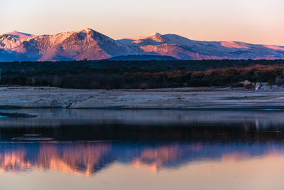 Scenic view of lake by mountains against sky