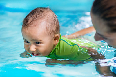 Mother and son swimming in pool
