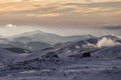 Scenic view of snowcapped mountains against sky during sunset