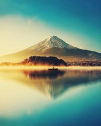 Scenic view of lake and mountains against clear blue sky