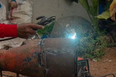 Cropped hand of man welding metal