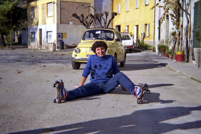 Rear view of woman sitting on street