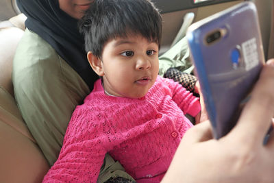 Close up of mother and baby child taking selfies in a car