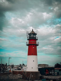 Lighthouse by sea against sky