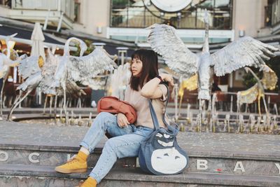 Full length of young woman using mobile phone