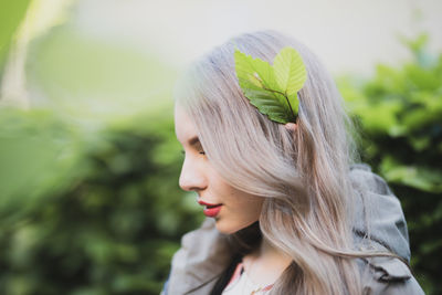 Close-up of young woman with leaves in hair