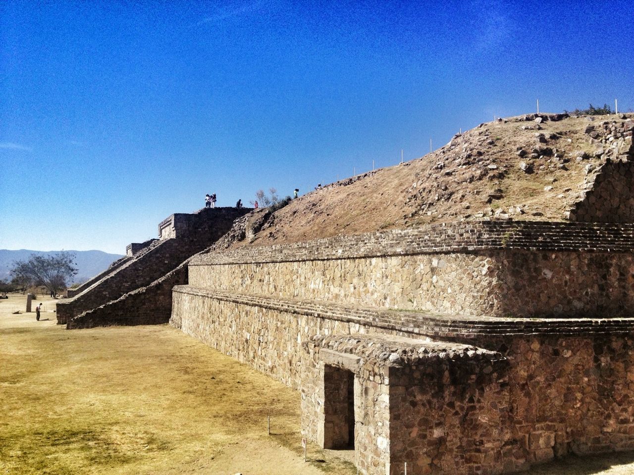 clear sky, blue, built structure, architecture, copy space, building exterior, history, mountain, sunlight, low angle view, old ruin, ancient, the past, stone wall, day, travel destinations, steps, ancient civilization, outdoors, travel