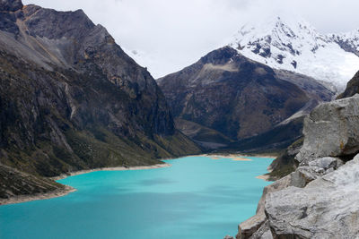 Scenic view of lake by mountains against sky