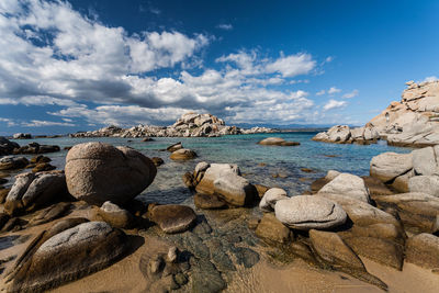 Rocks by sea against sky