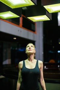 Woman looking at bright light above her