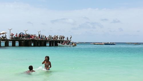 People enjoying in sea against sky