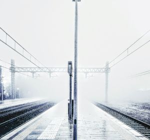 Snow covered railroad tracks against sky