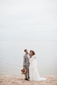 Bride and bridegroom standing at beach during wedding ceremony