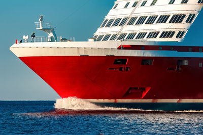 Red ship in sea against clear sky