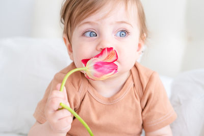 Cute baby girl holding flower