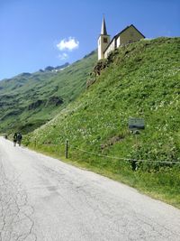 Road by building against sky